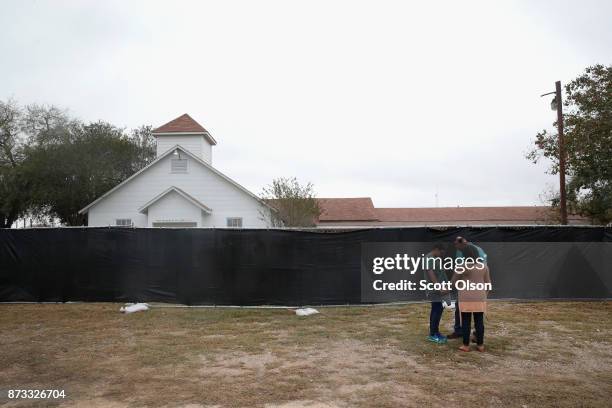 People pray in front of the First Baptist Church of Sutherland Springs on November 12, 2017 in Sutherland Springs, Texas. The congregation held...