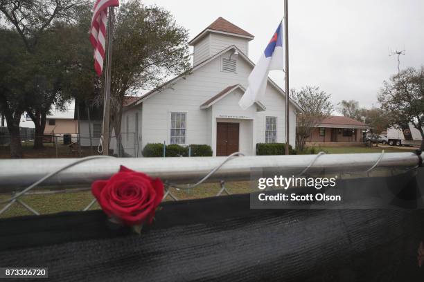 Rose is left in the fence surrounding the First Baptist Church of Sutherland Springs on November 12, 2017 in Sutherland Springs, Texas. The...