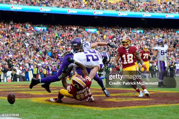 Wide receiver Jamison Crowder of the Washington Redskins attempts to pull in a catch as he is tackled by free safety Harrison Smith of the Minnesota...
