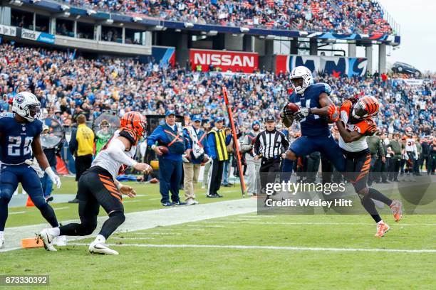 Wide Receiver Corey Davis of the Tennessee Titans tries to control the ball against Cornerback Dre Kirkpatrick of the Cincinnati Bengals at Nissan...