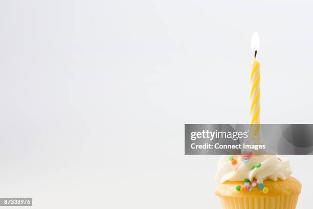 birthday candle on a cup cake - verjaardagskaars stockfoto's en -beelden