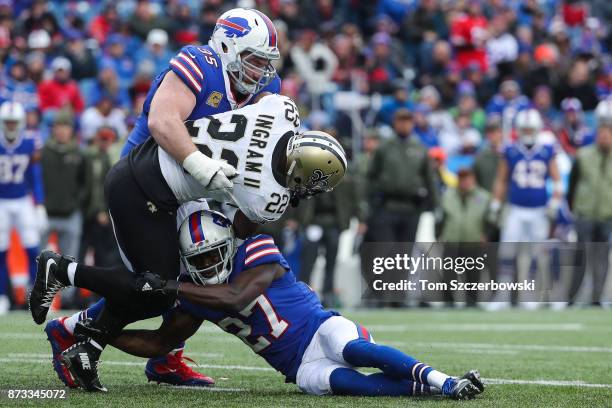 Mark Ingram of the New Orleans Saints is tackled by Kyle Williams of the Buffalo Bills and Tre'Davious White of the Buffalo Bills during the third...