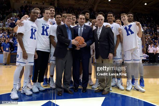 Head coach Mike Krzyzewski of the Duke Blue Devils poses for photos with Duke University President Vincent Price , Director of Athletics Kevin White...