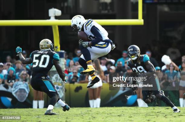 Keenan Allen of the Los Angeles Chargers leaps for the football in between Telvin Smith and Tashaun Gipson of the Jacksonville Jaguars in the second...