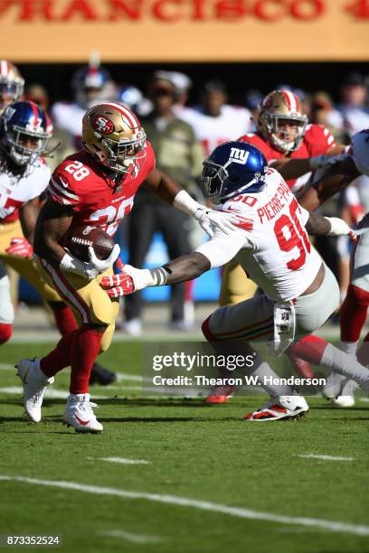 Carlos Hyde of the San Francisco 49ers breaks a tackle by Jason Pierre-Paul of the New York Giants during their NFL game at Levi's Stadium on...