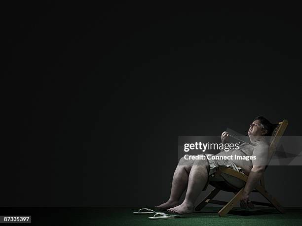 man in a deckchair - fat man tanning stock pictures, royalty-free photos & images