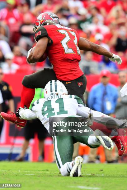 Running back Doug Martin of the Tampa Bay Buccaneers leaps over cornerback Buster Skrine of the New York Jets in the fourth quarter on November 12,...