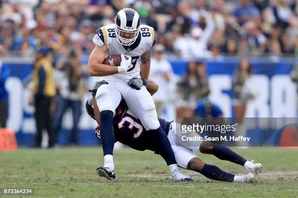 Eddie Pleasant of the Houston Texans tackles Tyler Higbee of the Los Angeles Rams during the second quarter of the game at the Los Angeles Memorial...