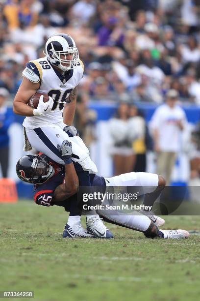 Eddie Pleasant of the Houston Texans tackles Tyler Higbee of the Los Angeles Rams during the second quarter of the game at the Los Angeles Memorial...