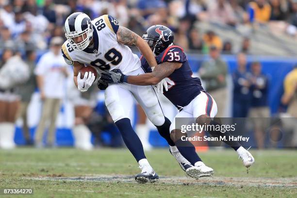 Eddie Pleasant of the Houston Texans tackles Tyler Higbee of the Los Angeles Rams during the second quarter of the game at the Los Angeles Memorial...