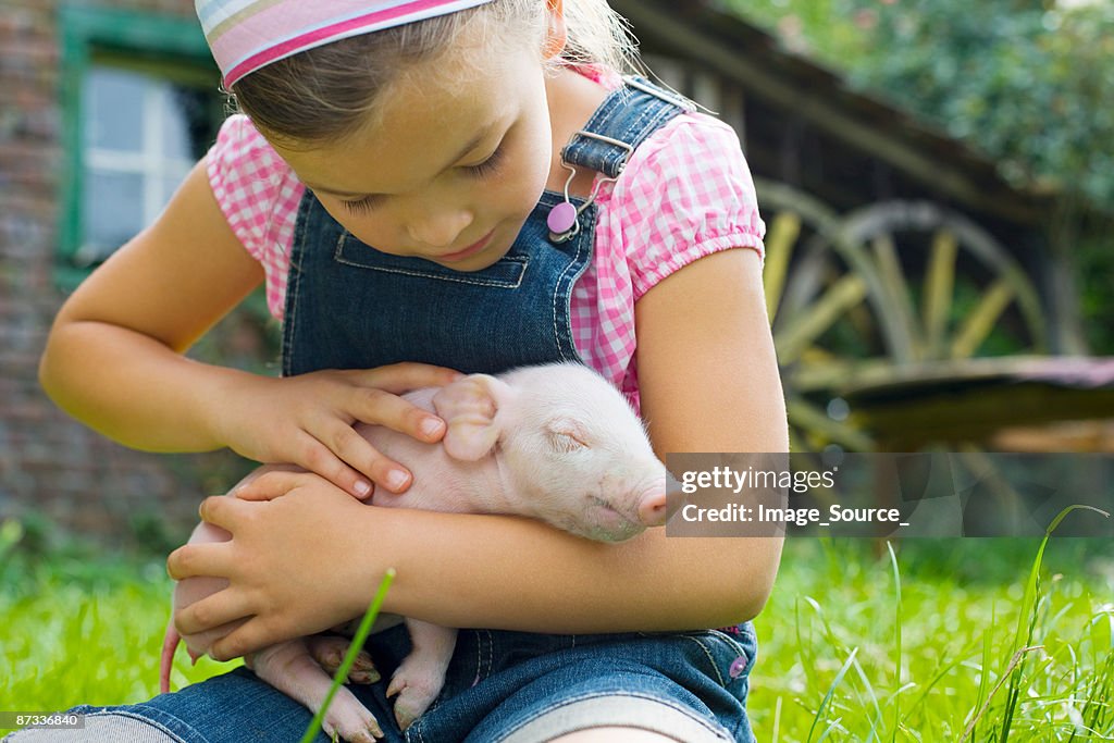 A girl holding a piglet