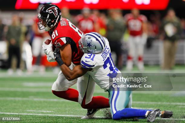 Austin Hooper of the Atlanta Falcons is tackled by Byron Jones of the Dallas Cowboys after a catch during the first half at Mercedes-Benz Stadium on...