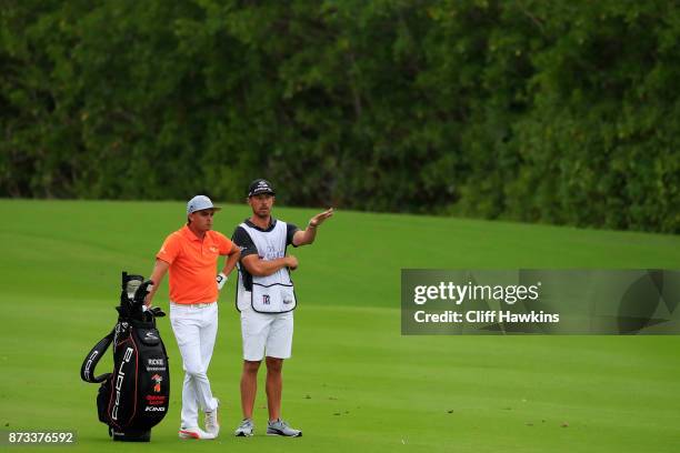 Rickie Fowler the United States talks with his caddie Joe Skovron on the 14th hole during the final round of the OHL Classic at Mayakoba on November...