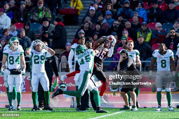 Ottawa RedBlacks wide receiver Diontae Spencer leaps up to catch the football with Saskatchewan Roughriders defensive back Kacy Rodgers II defending...