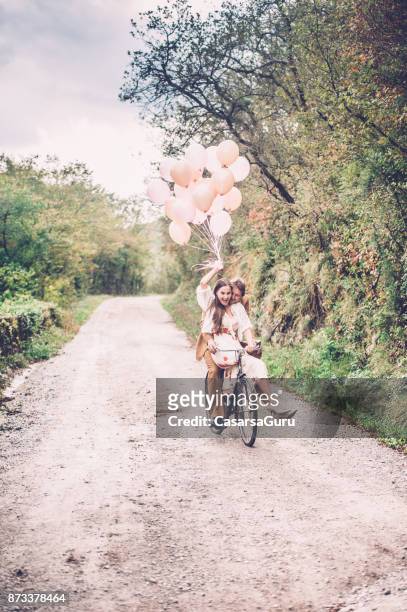 romantic young couple enjoying driving with vintage bicycle - hot air balloon ride stock pictures, royalty-free photos & images