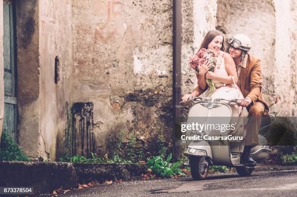 glückliches junges paar auf oldtimer vespa motorcyle genießen - roller vintage stock-fotos und bilder