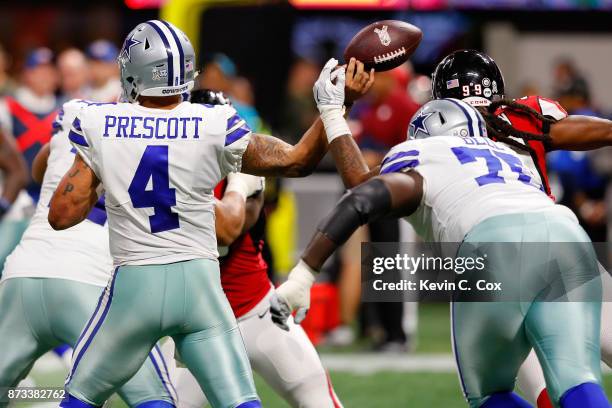 Adrian Clayborn of the Atlanta Falcons strips the ball from Dak Prescott of the Dallas Cowboys during the second half at Mercedes-Benz Stadium on...