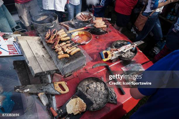 Tailgating food cooked in inventive ways on the hood of a red pinto at the Hammer's Lot at the Pinto Ron tailgate party before the Buffalo Bills...