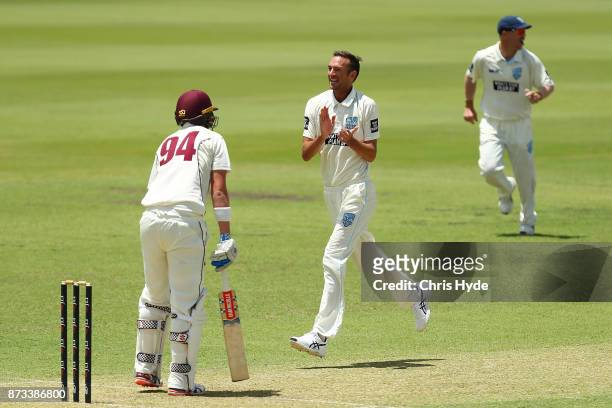 Trent Copeland of New South Wales celebrates with team mates after Matthew Renshaw of Queensland during day one of the Sheffield Shield match between...