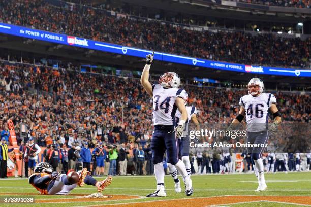 Rex Burkhead of the New England Patriots celebrates his 7-0 touchdown reception as Darian Stewart of the Denver Broncos lies on the grass during the...