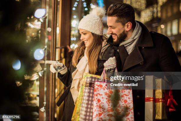 joy of buying christmas gifts - winter woman showing stock pictures, royalty-free photos & images