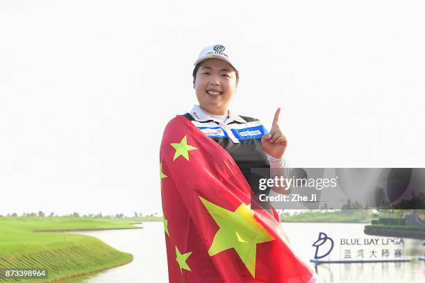 Shanshan Feng of China poses with the Chinese flag during a photo shoot after winning The Blue Bay LPGA, on November 13, 2017 in Hainan Island,...