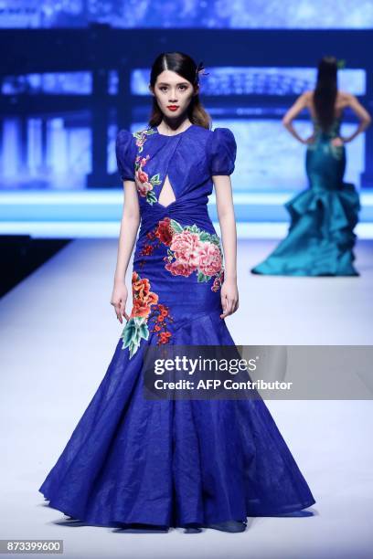 This photo taken on November 10, 2017 shows a model parading a creation from the Famory collection during 2017 China International Wedding and...