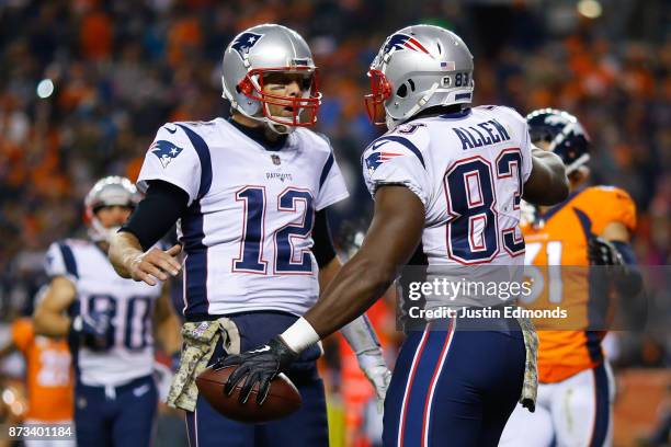 Tight end Dwayne Allen of the New England Patriots celebrates with Tom Brady after scoring a second quarter touchdown against the Denver Broncos at...