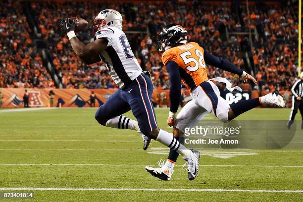 Dwayne Allen of the New England Patriots catches a touchdown pass as Von Miller of the Denver Broncos defends during the second quarter on Sunday,...