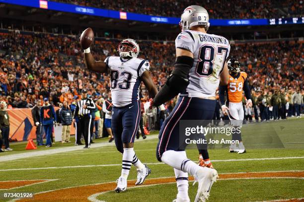 Dwayne Allen of the New England Patriots celebrates his touchdown reception with teammate Rob Gronkowski as Von Miller of the Denver Broncos reacts...