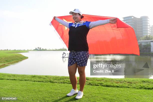 Shanshan Feng of China poses with the Chinese flag during a photo shoot after winning The Blue Bay LPGA, on November 13, 2017 in Hainan Island,...