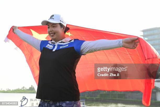 Shanshan Feng of China poses with the Chinese flag during a photo shoot after winning The Blue Bay LPGA, on November 13, 2017 in Hainan Island,...