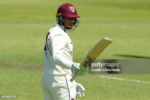 Usman Khawaja of Queensland celebrates his half century during day one of the Sheffield Shield match between Queensland and New South Wales at Allan...
