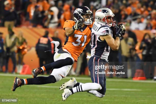 Danny Amendola of the New England Patriots catches a pass while defended by Justin Simmons of the Denver Broncos in the third quarter. The Denver...