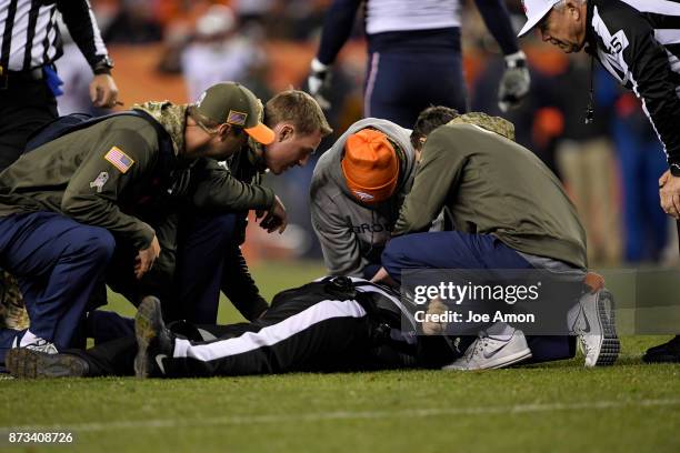 Referee Jeff Rice is tended to by medical staff after being knocked out by Trevor Reilly of the New England Patriots during the third quarter on...