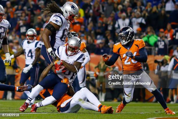 Running back Dion Lewis of the New England Patriots works for a third quarter rushing touchdown against the Denver Broncos at Sports Authority Field...