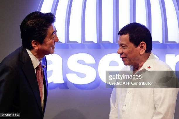Japanese Prime Minister Shinzo Abe talks to Philippine President Rodrigo Duterte before the opening ceremony of the 31st Association of Southeast...