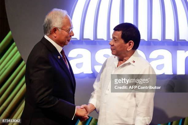 Malaysia's Prime Minister Najib Razak shakes hands with Philippine President Rodrigo Duterte before the opening ceremony of the 31st Association of...
