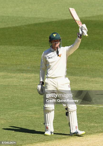 George Bailey of Tasmania raises his bat after making 100 during day one of the Sheffield Shield match between Victoria and Tasmania at Melbourne...