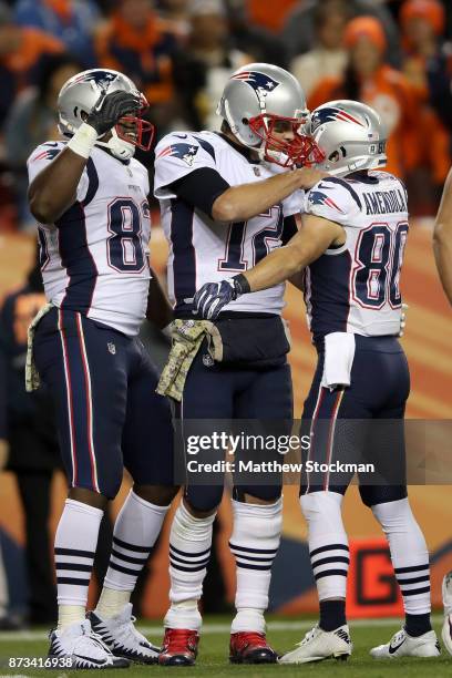 Danny Amendola of the New England Patriots is congratulated by Dwayne Allen and Tom Brady after scoring a touchdown against the Denver Broncos at...