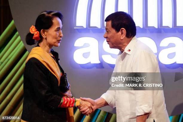 Myanmar's State Councellor and Foreign Minister Aung San Suu Kyi shakes hands with Philippine President Rodrigo Duterte before the opening ceremony...