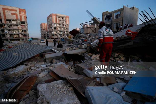 Rescue personnel conduct search and rescue work following a 7.3-magnitude earthquake at Sarpol-e Zahab in Iran's Kermanshah province on November 13,...