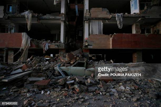 Flattened vehicle underneath building rubble is seen following a 7.3-magnitude earthquake at Sarpol-e Zahab in Iran's Kermanshah province on November...