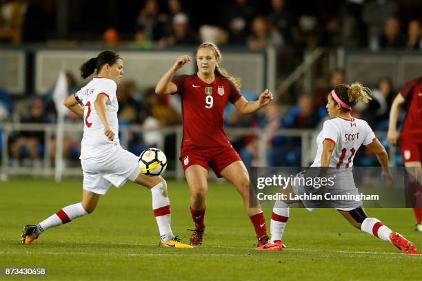 Lindsey Horan of the United States passes the ball between Christine Sinclair and Desiree Scott of Canada during the friendly match at Avaya Stadium...