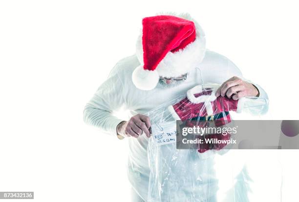 santa claus looking down at shrunken dry cleaned santa costume - man in tight pants stock pictures, royalty-free photos & images