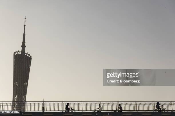 Cyclists ride Ofo Inc. Bicycles on the Liede Bridge over the Pearl River in Guangzhou, China, on Wednesday, Nov. 2, 2017. China is poised for an...