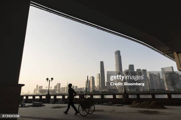 Worker pulls a cart under the Liede Bridge over the Pearl River in Guangzhou, China, on Wednesday, Nov. 1, 2017. China is poised for an acceleration...