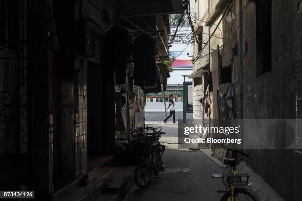 Pedestrian walks past houses in Xi Cun, an old neighborhood slated for demolition and redevelopment in Guangzhou, China, on Wednesday, Nov. 1, 2017....