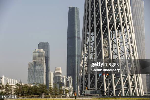 Gardener waters the lawn in front of the residential and commercial buildings including the Canton Tower, right, in Guangzhou, China, on Wednesday,...