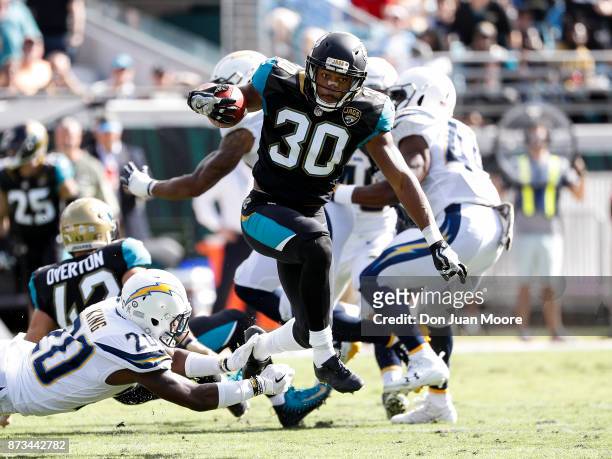 Runningback Corey Grant of the Jacksonville Jaguars avoids a tackle by Cornerback Desmond King of the Los Angeles Chargers on a fake punt return for...